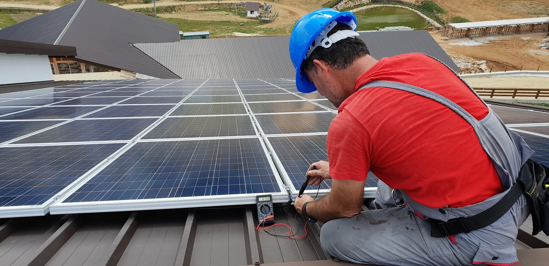 Elektriker som mäter en solcellsanläggning på ett tak